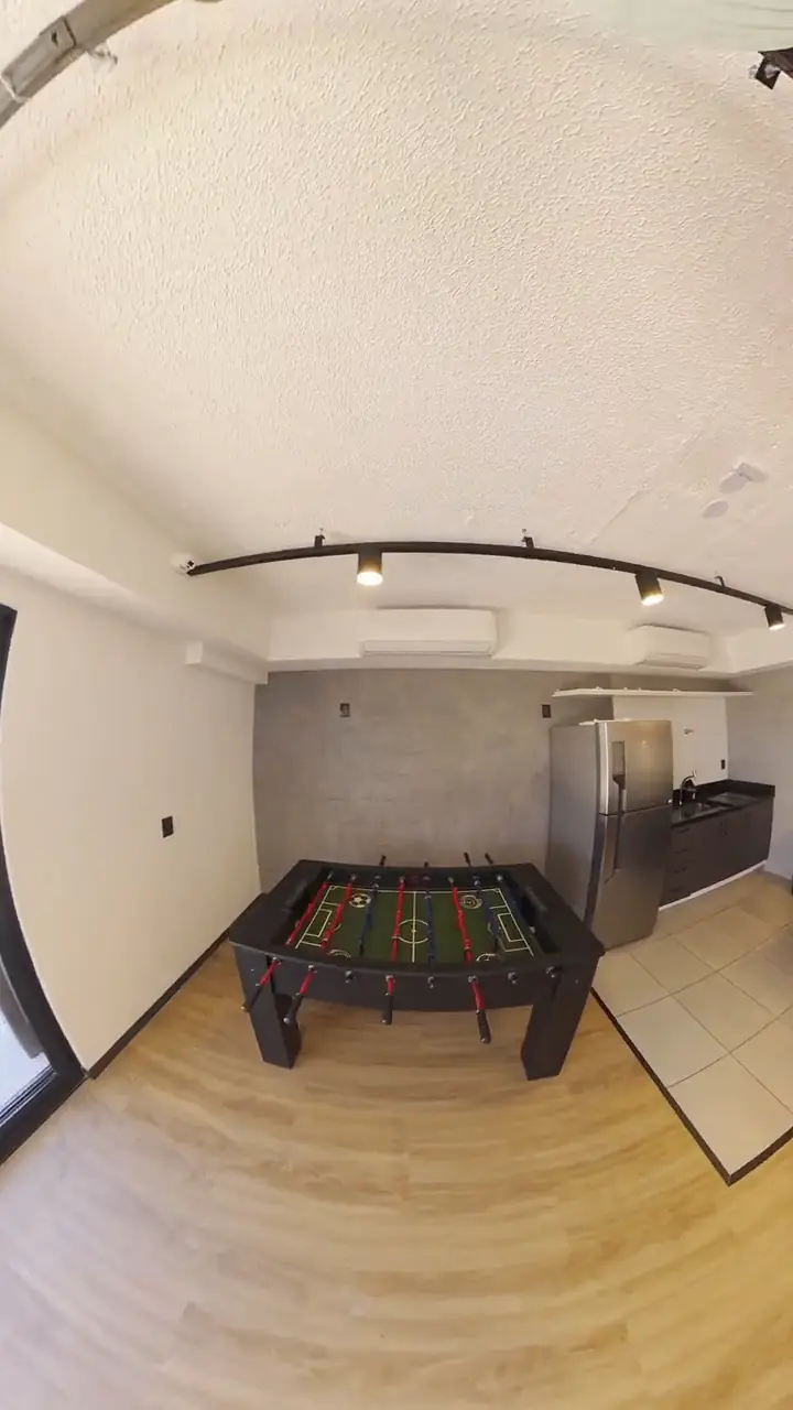 Área de convivência com cozinha, pebolim e luminárias, em vídeo 360º reenquadrado